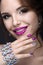 Beautiful girl with a bright evening make-up and purple manicure with rhinestones. Nail design. Beauty face.