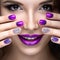 Beautiful girl with a bright evening make-up and purple manicure with rhinestones. Nail design. Beauty face.