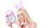 Beautiful girl in bunny ears holding pink clock