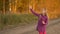 Beautiful girl catches soap bubbles. Autumn scenery forest road. Golden autumn. Slow motion handheld