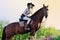 Beautiful girl with chestnut horse in evening field