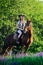 Beautiful girl with chestnut horse in evening field