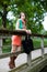 Beautiful Girl with Cloth Shopping Bags Leaning on Wooden Bridge