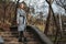 Beautiful girl in a coat walks down stairs in autumn Park. copy space