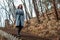 Beautiful girl in a coat walks down stairs in autumn Park. copy space