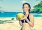 Beautiful girl with coconut on background of sea,