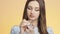 Beautiful girl on a colored studio background enjoying the aroma of perfume from a bottle, a young woman sniffs and poses, the con