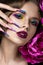 Beautiful girl with colorful make-up, flowers, retro hairstyle and long nails. Manicure design. The beauty of the face.