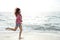 Beautiful girl with colorful windbreaker running on the beach