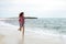 Beautiful girl with colorful windbreaker running on the beach