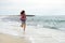 Beautiful girl with colorful windbreaker running on the beach