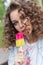 Beautiful girl with curly with a naked lips eating color ice cream in a cafe in the park a bright summer day