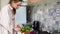 Beautiful girl cuts the avocado in the kitchen and prepare a smoothie.