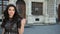 Beautiful girl dark-haired, in black dress, crown on her head, posing for camera