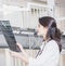 Beautiful girl doctor in a white coat examines X-ray photo of the patient to identify the problem. Professional conversation, cons