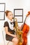 Beautiful girl in dress holding alto saxophone