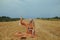 A beautiful girl in a dress sits on a wheat field. Fabulous photo of a blonde outside the city. A woman without allergies holds