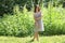 Beautiful girl in dress standing in woods amid tall grass