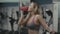 Beautiful girl drinking protein in gym. Female drinks water after exercise
