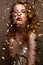 Beautiful girl in an evening dress and gold curls. Model in New Year`s image with glitter and tinsel.