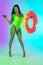 Beautiful girl in fashionable swimsuit isolated on gradient studio background in neon light. Summer, resort, fashion and