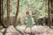 A beautiful girl with flying hair in a pine forest. Good forest witch in a green dress