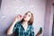 Beautiful girl with freckles blowing bubbles near pink wall