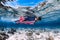 Beautiful girl freediver swim over sandy sea bottom with United States flag.