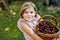 Beautiful girl in the garden. Happy girl with cherries. Preschol child with basket full of ripe berries and fun cherry