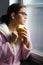 Beautiful girl with glasses drinking morning coffee in front of window