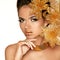 Beautiful Girl With Golden Flowers. Beauty Model Woman Face. Per