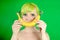 Beautiful girl with green hair does smile with banana on green background