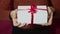 Beautiful girl hands hold a gift envelope with a red ribbon.