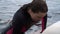 Beautiful girl and a handsome guy in wetsuits are actively resting on the river