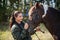 A beautiful girl is happy with her horse and shows her love and tenderness