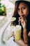 Beautiful girl with the hat, drinking fresh and refreshing pineapple juice, summer holiday vacation