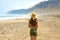 Beautiful girl with hat looking to suggestive landscape of Caleta Famara, Lanzarote, Canary Islands