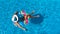 Beautiful girl in hat in swimming pool aerial top view from above, woman relaxes and swims on inflatable ring donut and has fun