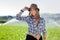 Beautiful girl with hat wearing shirt in a field with water sprinklers