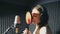 Beautiful girl in headphones sings in sound studio. Young singer emotionally recording new song. Lady sings to