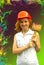 Beautiful girl in a helmet with construction hammer on a green and burgundy background with splashes of paint