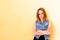 Beautiful girl with her hair standing on yellow background. She with all her appearance portrays the emotion of passion a