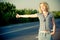 Beautiful girl hitchhiking on the road