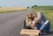 Beautiful girl hitchhiking on the road traveling.