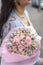 Beautiful girl holding bouquet of dried flowers in hands. Pink dried flowers bouquet. Preserved Rose flowers bouquet.