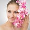 Beautiful girl holding orchid flower in her hands