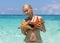 Beautiful girl holding two starfishes in her hands