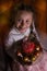 Beautiful girl holds Easter cake and eggs on a plate and smiling at the camera. Easter holiday