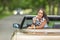 Beautiful girl laughing into a camera turned backwards on a seat of a cabriolet with another car approaching