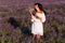 Beautiful girl is among the lavender fields. Beautiful girl at sunset. The girl on the flower field. Woman walking in the lavender